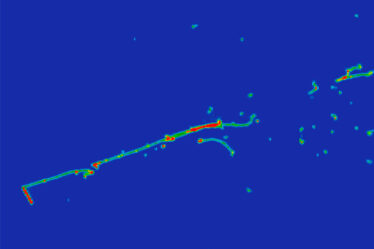 A blue image with a greenish line going from roughly bottom left to top right, with a number of dots and smudges, also greenish, toward the top-right quadrant of the image.
